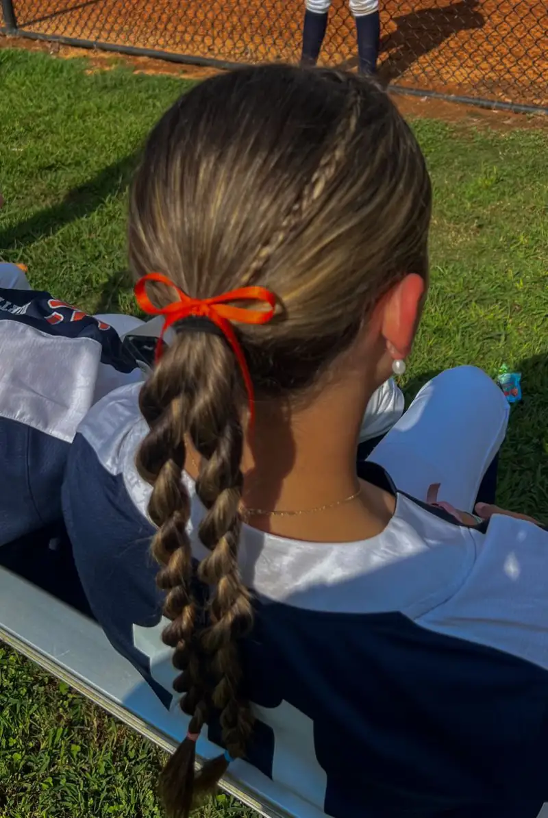 ribbon tie braided ponytail softball hairstyle