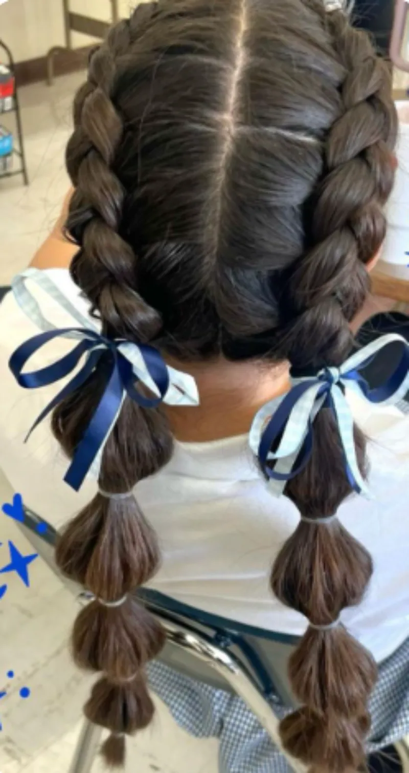 double braids with bow accent softball hairstyle