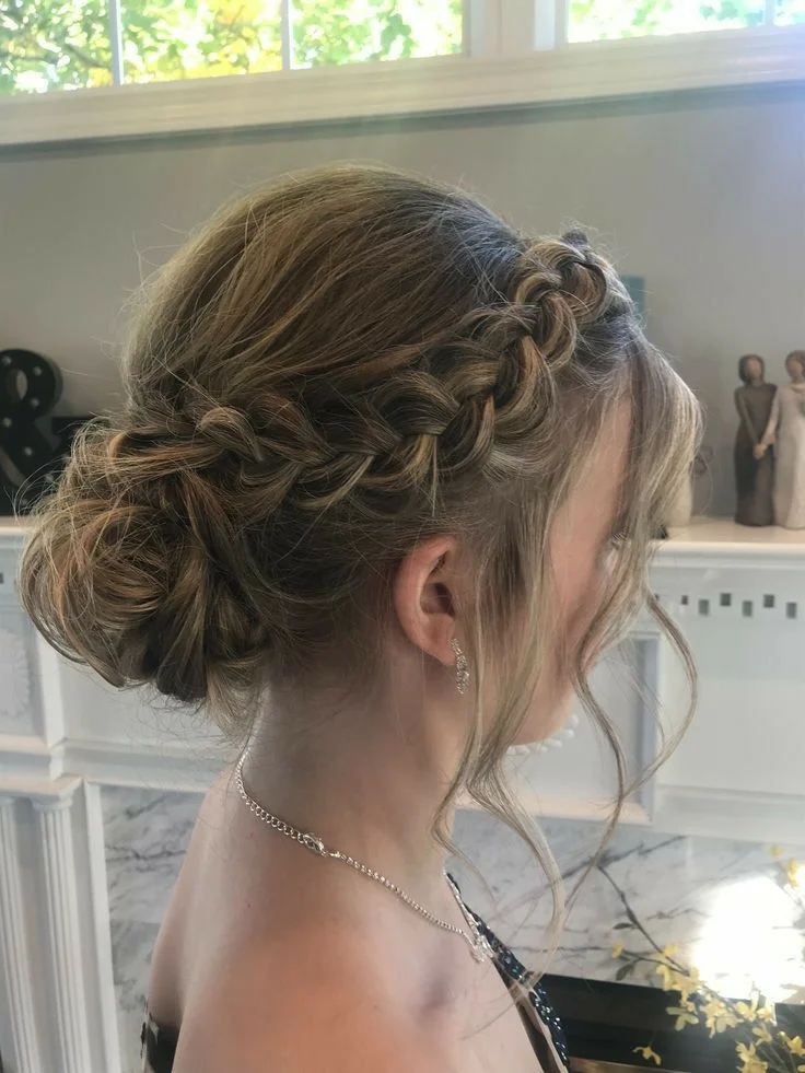 braided low bun with soft waves winter formal hairstyles